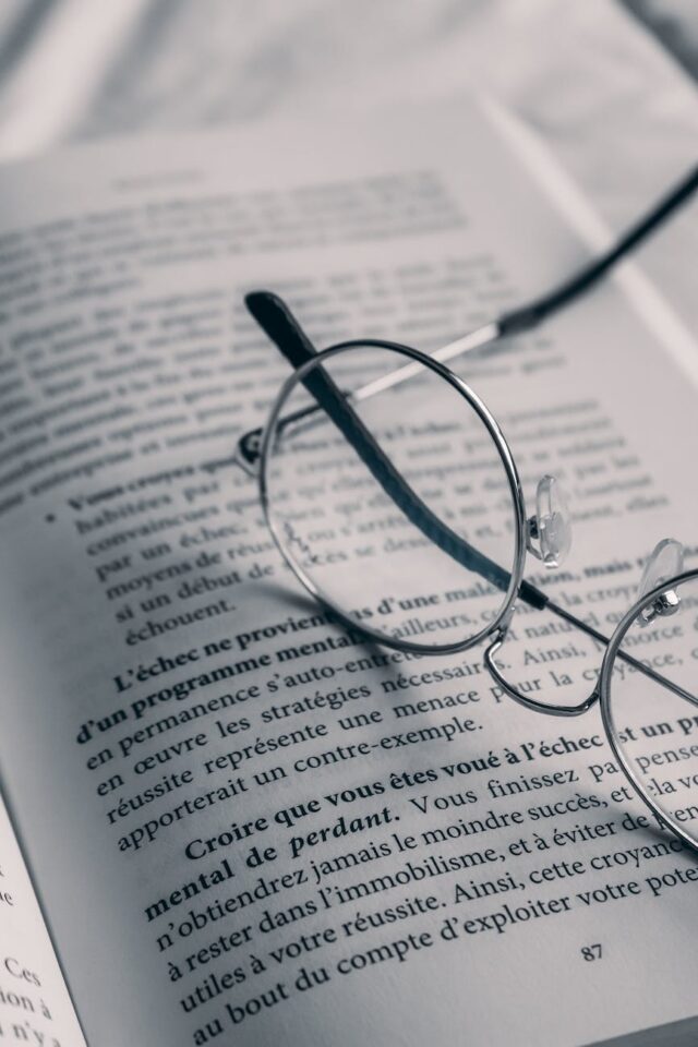 close up photo of eyeglasses on a book